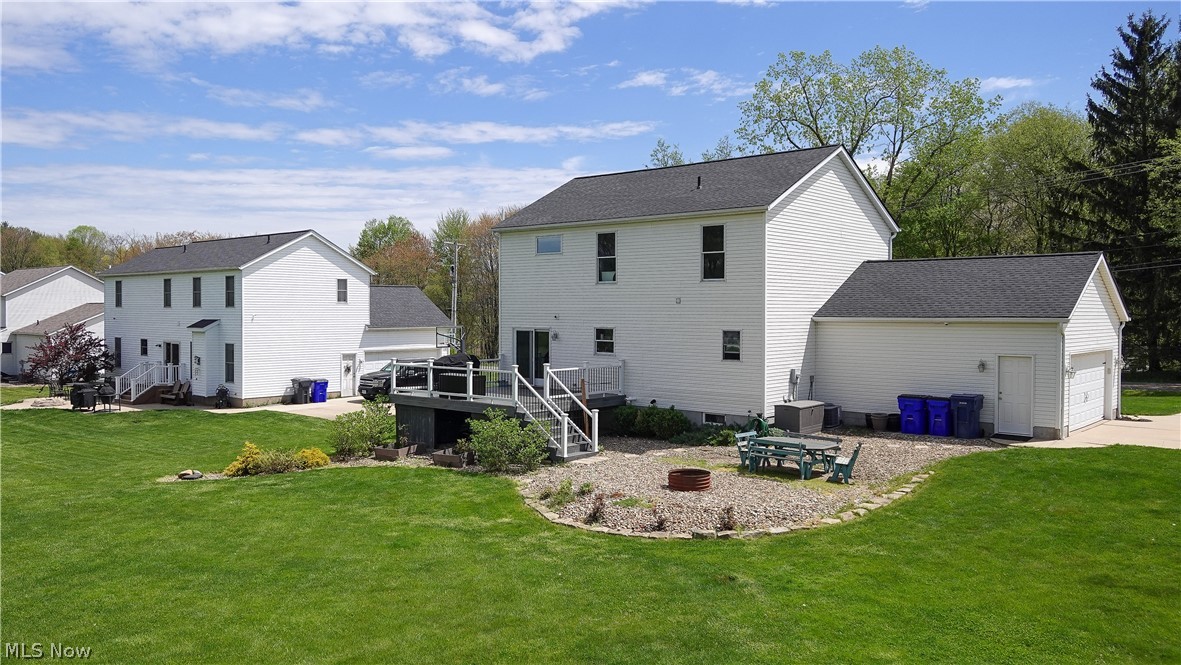 4849 Edson Road Kent, OH 44240 - Photo 38 of 50 Back of house featuring a garage, an outdoor structure, and a lawn