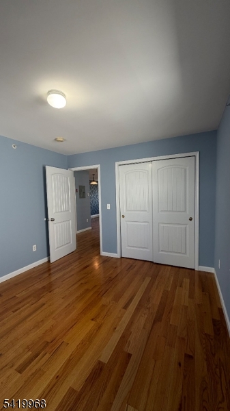 159 Lafayette Street, Unit 3 Newark, NJ 07105 - Photo 17 of 17 a view of an empty room with wooden floor and kitchen