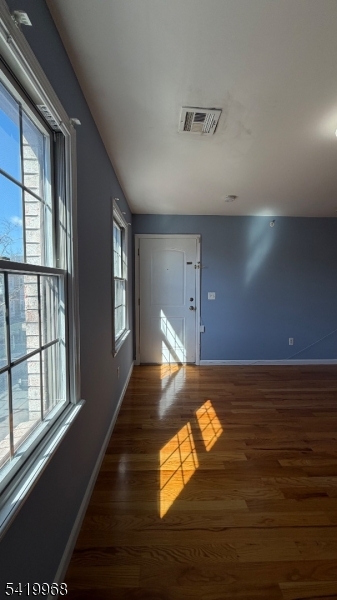 159 Lafayette Street, Unit 3 Newark, NJ 07105 - Photo 3 of 17 a view of an empty room with wooden floor and a window