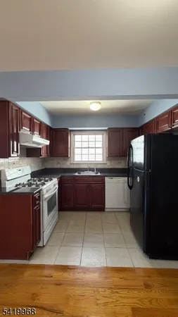 a kitchen with stainless steel appliances granite countertop a refrigerator a stove and a sink