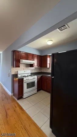 a kitchen with stainless steel appliances granite countertop a refrigerator and a stove