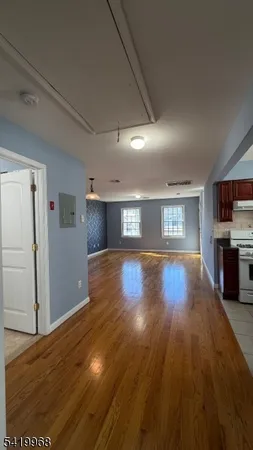 a view of empty room with wooden floor
