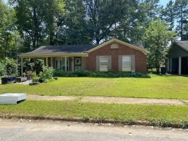 a front view of a house with yard and green space