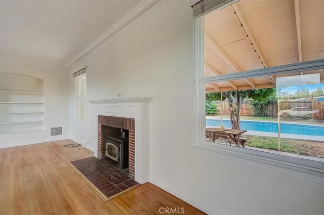 a view of empty room with wooden floor and fireplace