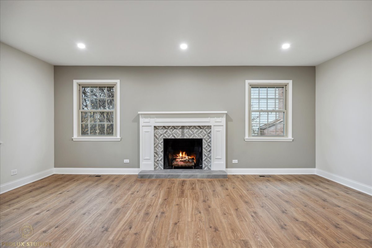 230 Stonegate Road Buffalo Grove, IL 60089 - Photo 3 of 13 a view of an empty room with wooden floor fireplace and a window