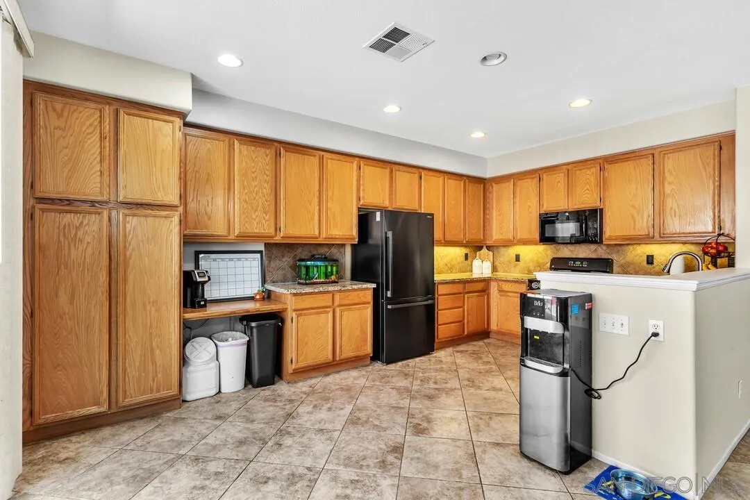 4460 Cloudywing Road Hemet, CA 92545 - Photo 11 of 41 a kitchen with stainless steel appliances granite countertop a refrigerator stove top oven and sink