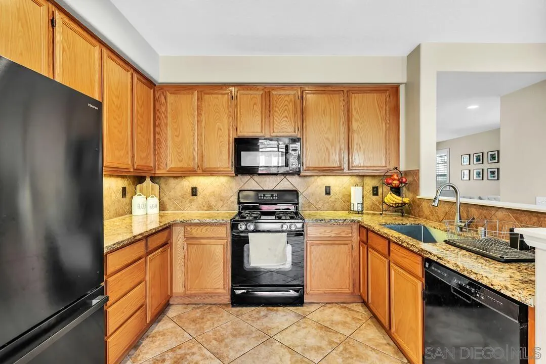 4460 Cloudywing Road Hemet, CA 92545 - Photo 13 of 41 a kitchen with a stove a sink and a refrigerator