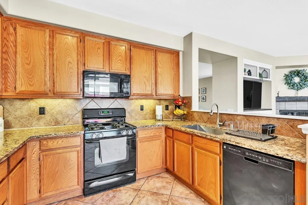 4460 Cloudywing Road Hemet, CA 92545 - Photo 14 of 41 a kitchen with stainless steel appliances granite countertop a stove sink and cabinets