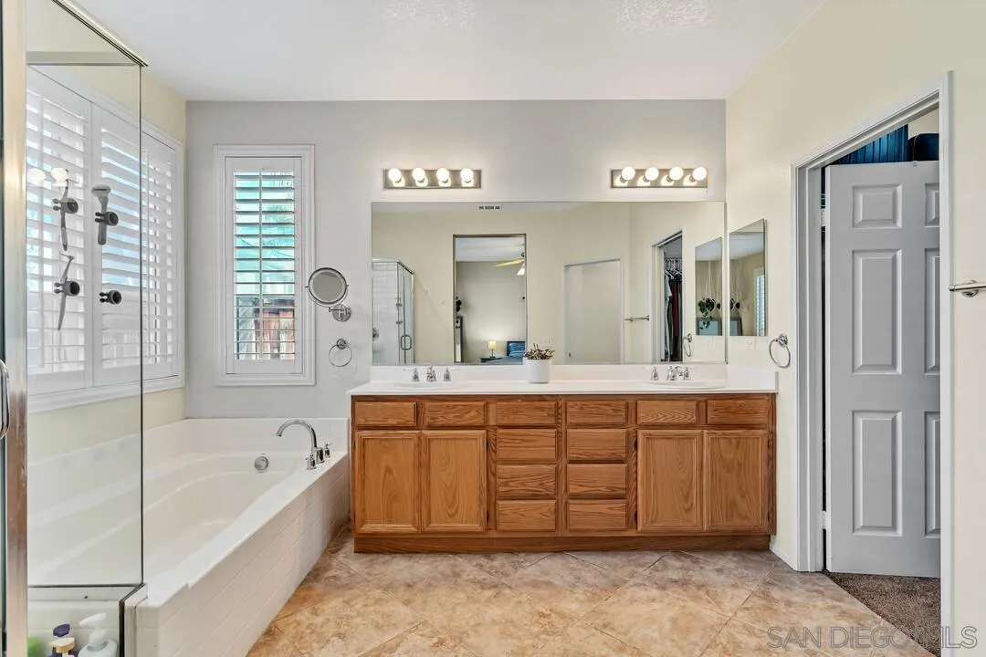 4460 Cloudywing Road Hemet, CA 92545 - Photo 19 of 41 a spacious bathroom with a tub a double vanity sink and a mirror
