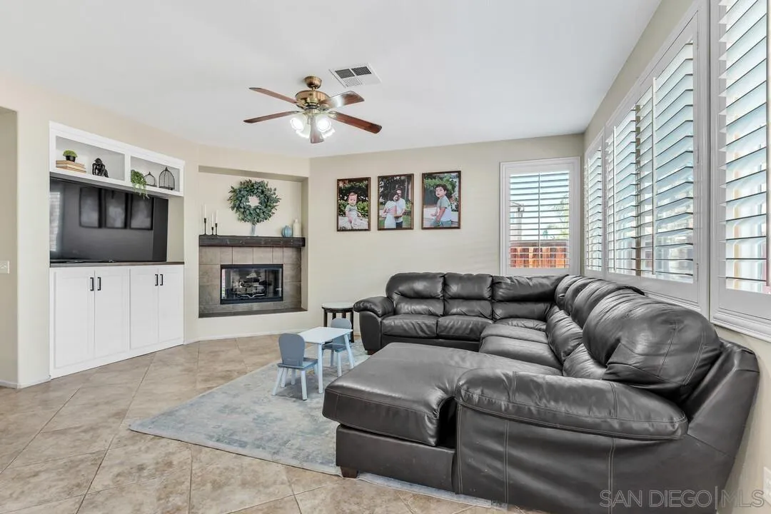 4460 Cloudywing Road Hemet, CA 92545 - Photo 8 of 41 a living room with furniture a flat screen tv and a fireplace