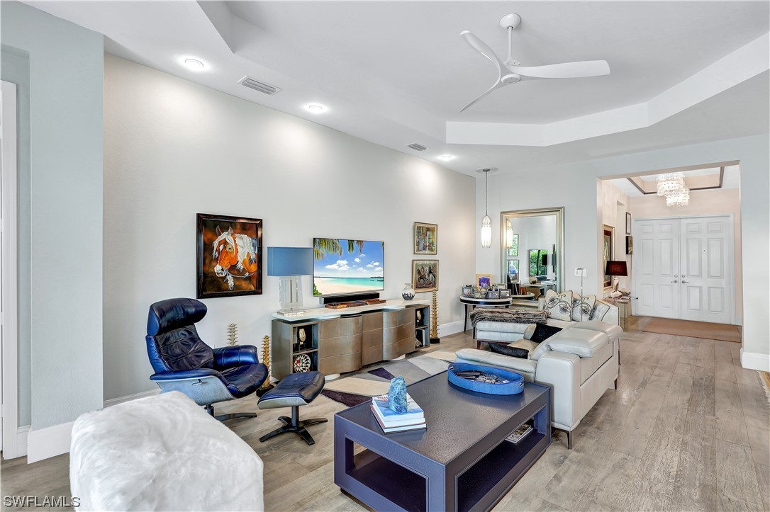 13772 Luna Drive Naples, FL 34109 - Photo 22 of 34 a living room with furniture a flat screen tv and kitchen view