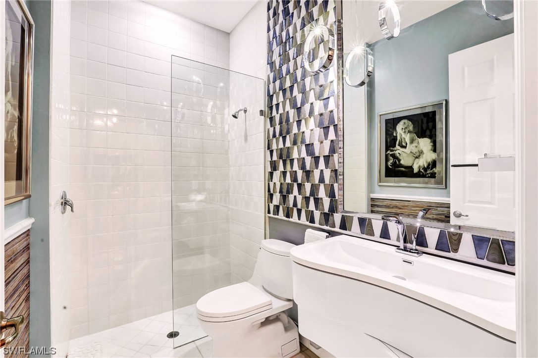 13772 Luna Drive Naples, FL 34109 - Photo 25 of 34 a bathroom with a sink toilet and shower