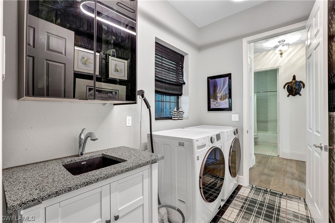13772 Luna Drive Naples, FL 34109 - Photo 26 of 34 a utility room with stainless steel appliances granite countertop a sink and a washer dryer
