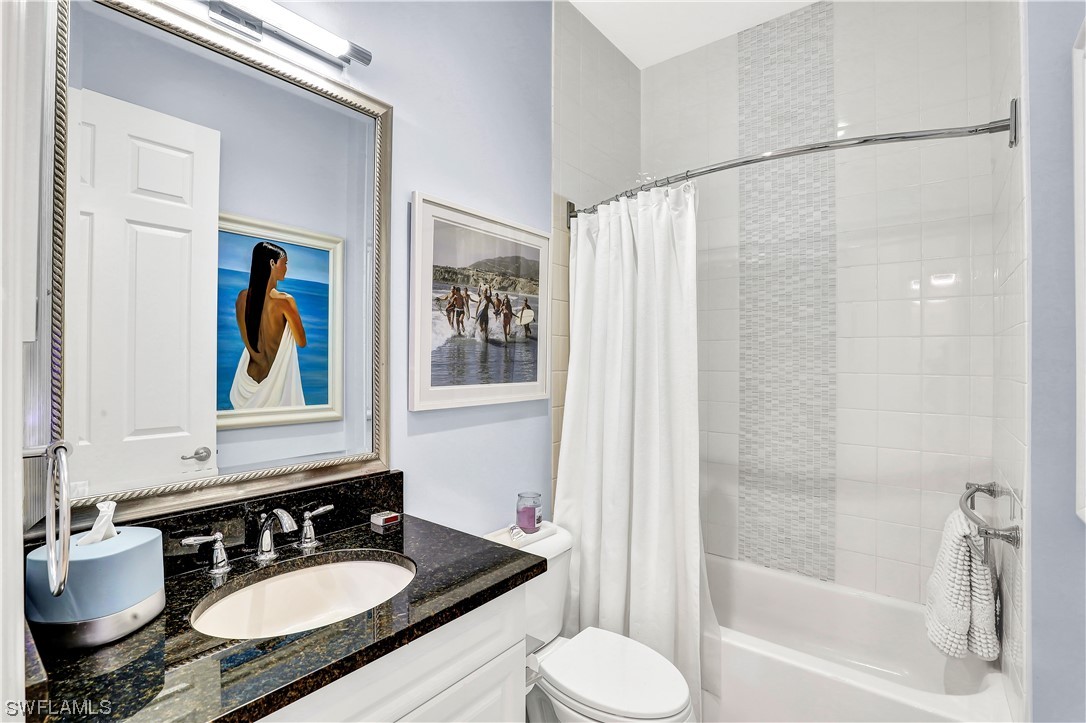 13772 Luna Drive Naples, FL 34109 - Photo 28 of 34 a bathroom with a granite countertop sink mirror and a bathtub