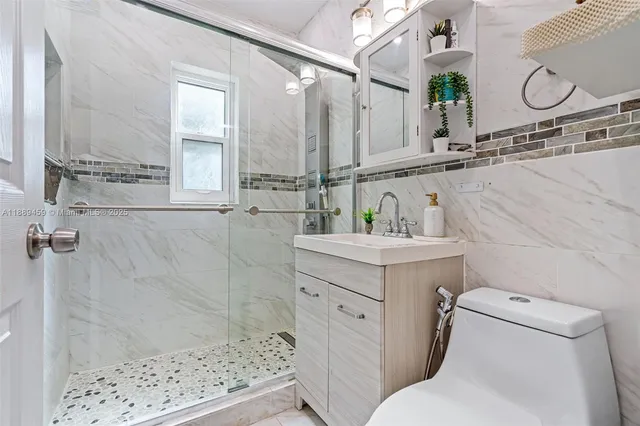 a bathroom with a sink a toilet and shower