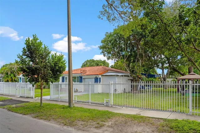 a view of a house with a yard deck and a palm tree