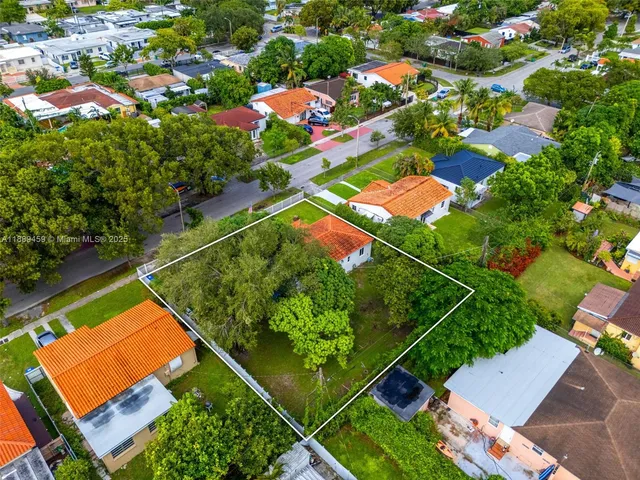 an aerial view of a tennis ground and a houses