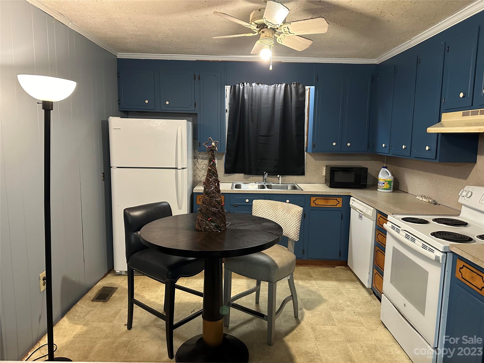 4198 Cat Square Road Vale, NC 28168 - Photo 5 of 14 a kitchen with a stove a sink a kitchen island with a dining table and chairs