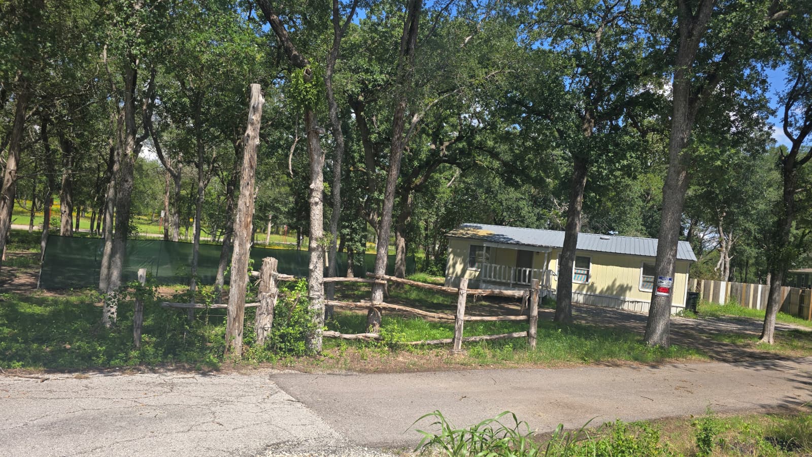 8607 Burleson Manor Road, Unit A Manor, TX 78653 - Photo 11 of 13 A rural retreat with a charming home nestled among mature trees and a rustic fence.