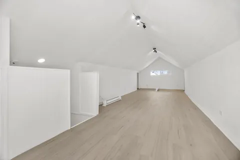 a view of a room with wooden floor and white walls
