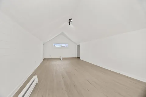 a view of a room with wooden floor and window