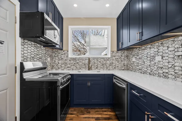 a kitchen with stainless steel appliances granite countertop a sink stove and cabinets