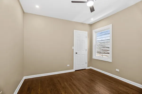 an empty room with a window and wooden floor