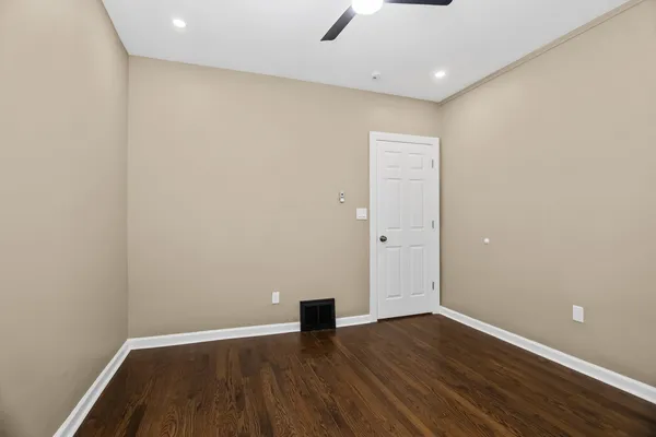 a view of an empty room with wooden floor