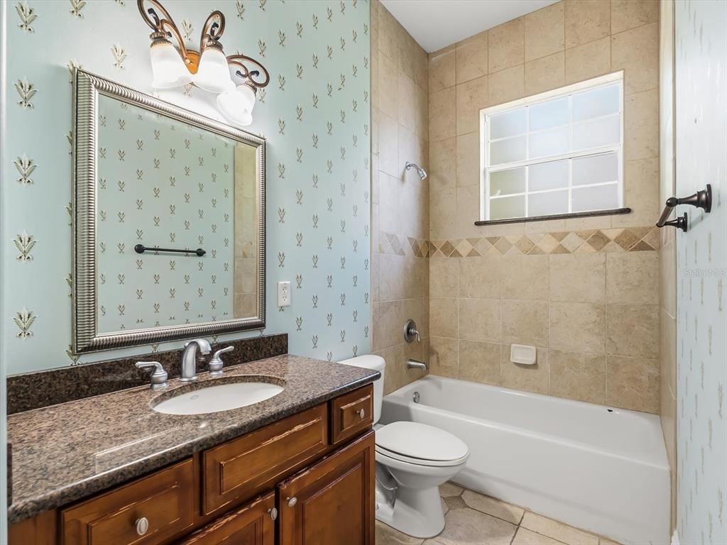1554 Corolla Court Reunion, FL 34747 - Photo 23 of 71 a bathroom with a granite countertop sink toilet and shower