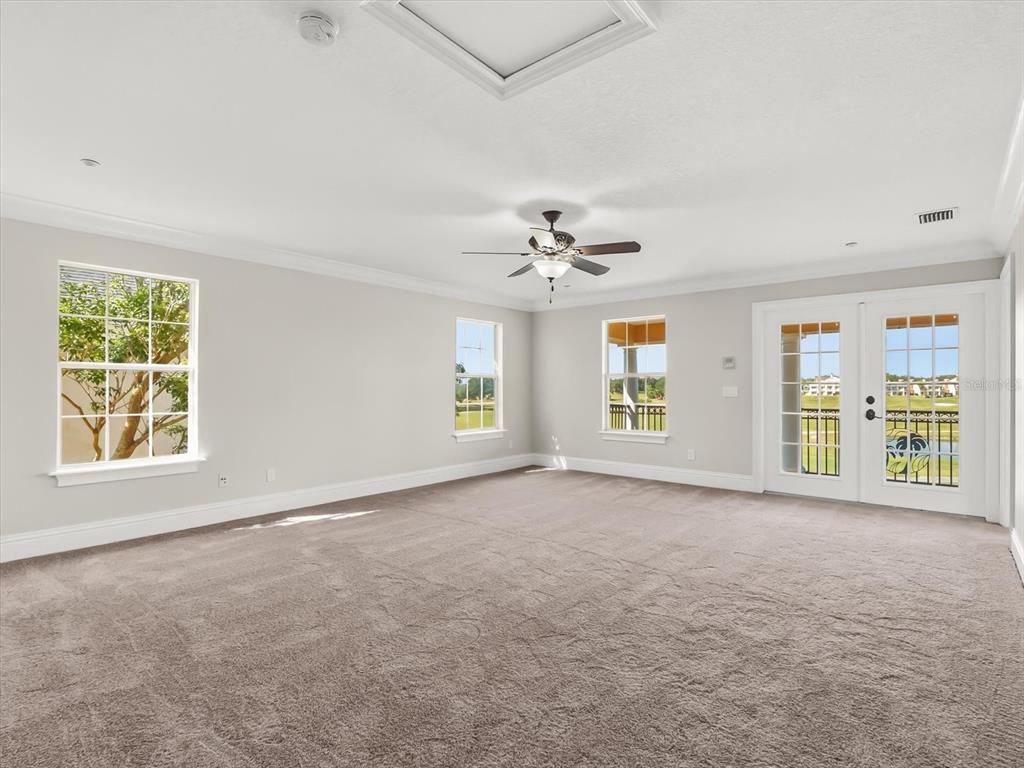 1554 Corolla Court Reunion, FL 34747 - Photo 30 of 75 an empty room with windows and chandelier fan
