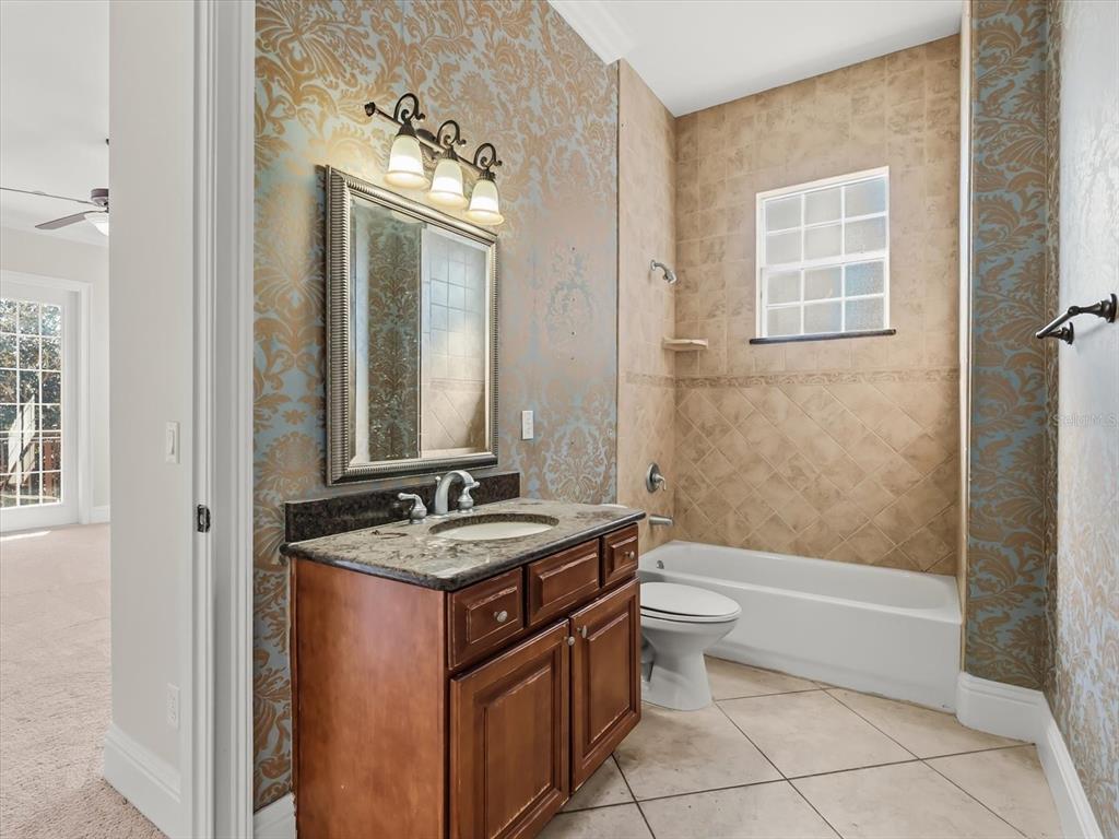 1554 Corolla Court Reunion, FL 34747 - Photo 40 of 75 a bathroom with a granite countertop sink toilet and shower