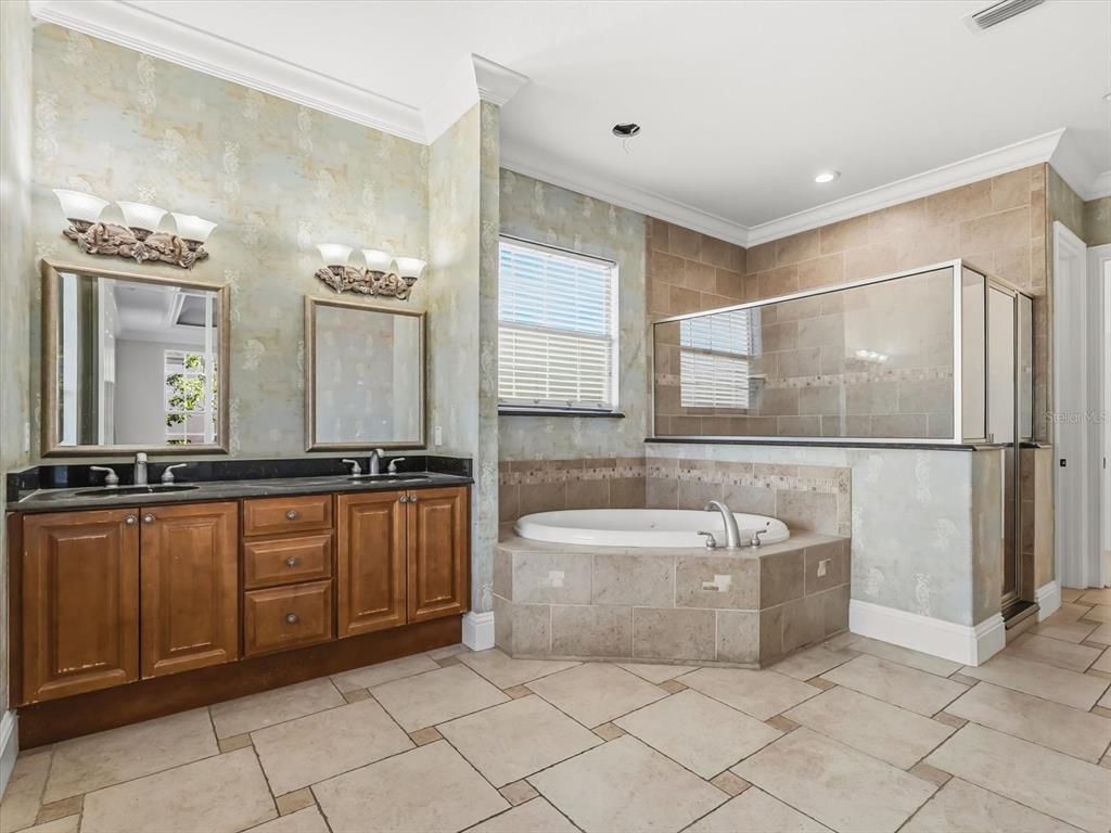 1554 Corolla Court Reunion, FL 34747 - Photo 42 of 75 a spacious bathroom with a double vanity sink a mirror and a bathtub
