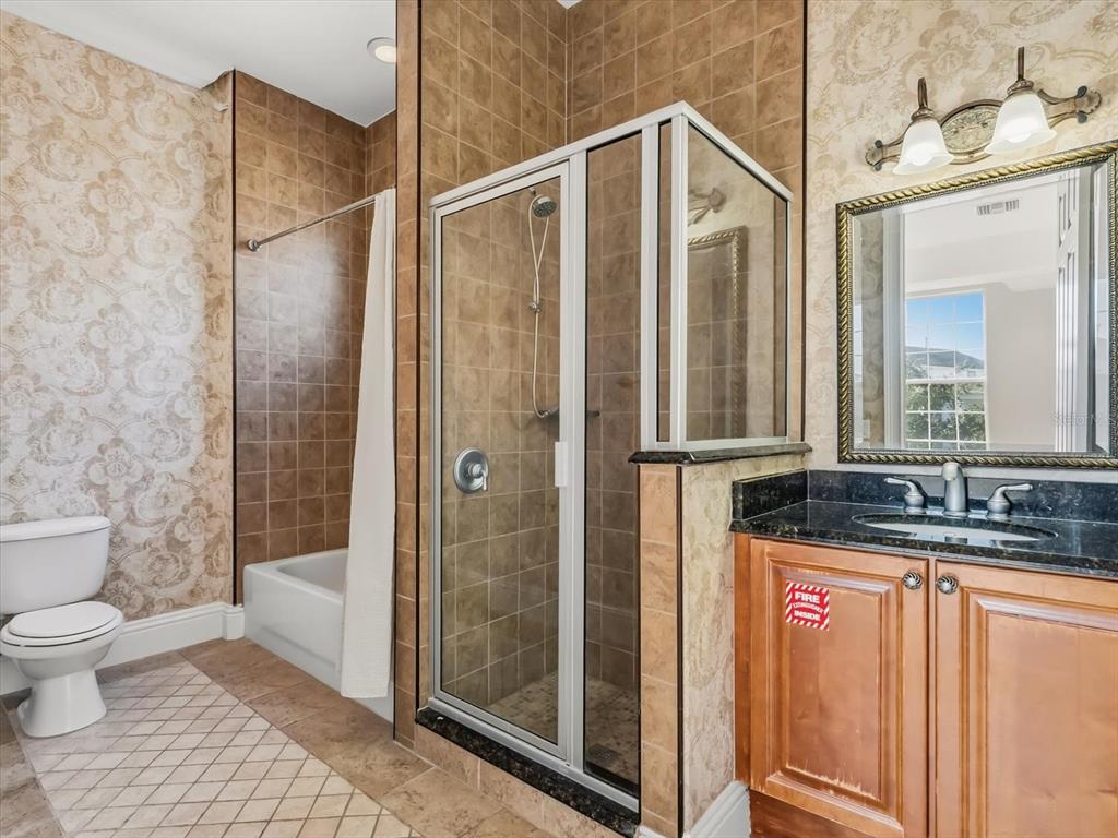 1554 Corolla Court Reunion, FL 34747 - Photo 50 of 71 a bathroom with a granite countertop sink a toilet and shower