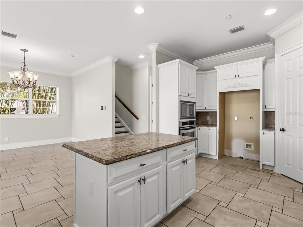 1554 Corolla Court Reunion, FL 34747 - Photo 8 of 71 a kitchen with stainless steel appliances granite countertop a sink and a refrigerator