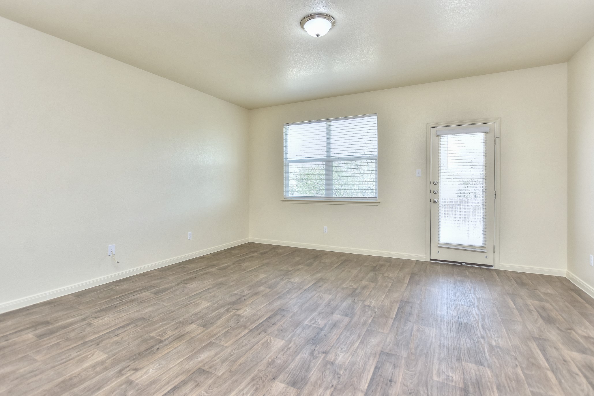 6201 Kildare Drive Georgetown, TX 78626 - Photo 16 of 29 Empty room featuring wood finished floors, baseboards, and a wealth of natural light