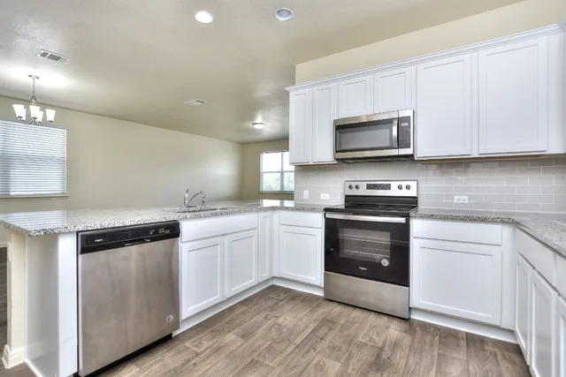 a kitchen with granite countertop a sink and steel appliances