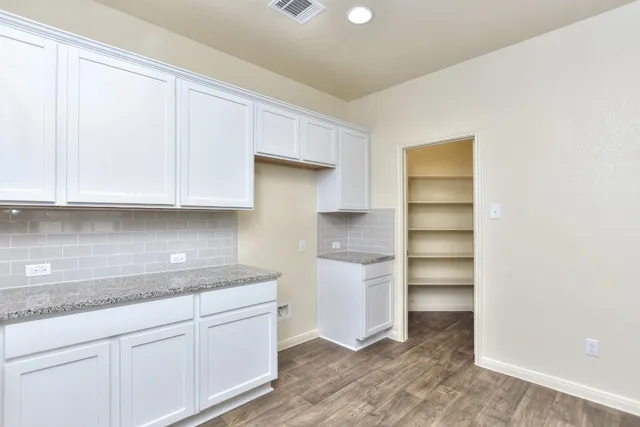 a kitchen with granite countertop white cabinets and white appliances