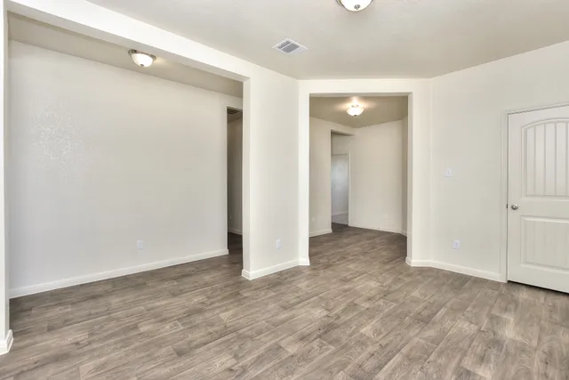 a view of an empty room with wooden floor