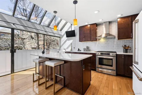 a kitchen with stainless steel appliances granite countertop a stove a sink and a refrigerator