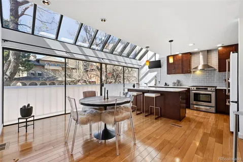 a kitchen with a refrigerator a stove a sink dishwasher with a dining table and chairs