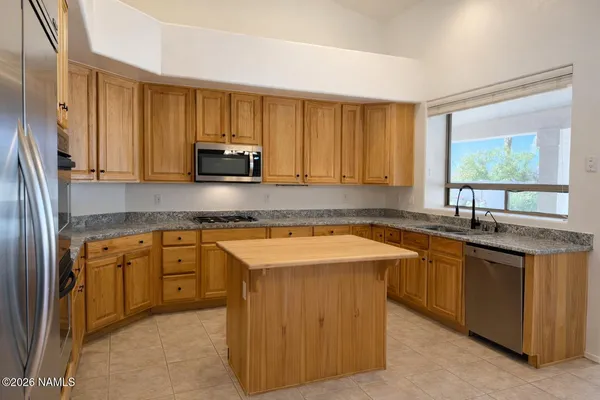 a kitchen with stainless steel appliances granite countertop a sink stove and cabinets