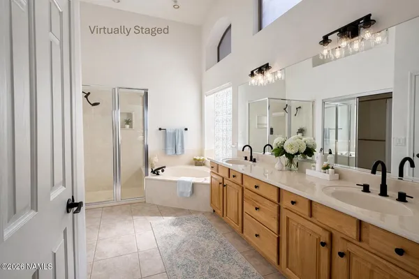 a spacious bathroom with a double vanity sink a large mirror and a bathtub