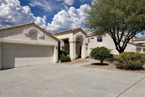 a view of a white house with a large tree and a yard