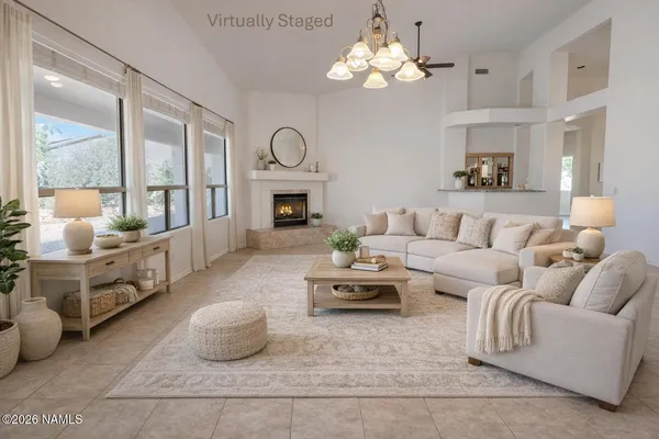 a living room with furniture chandelier and a fireplace