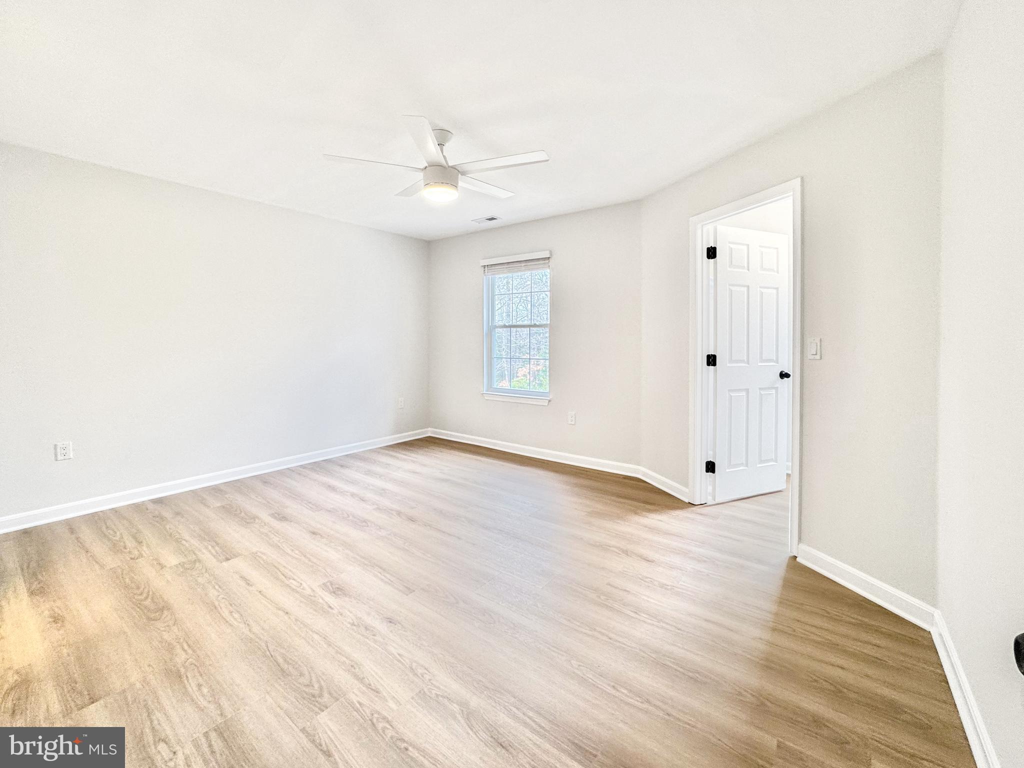 640 Santa Fe Trail Lusby, MD 20657 - Photo 18 of 32 an empty room with wooden floor ceiling fan and windows
