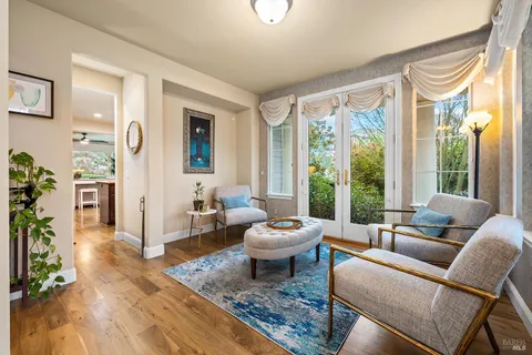 a open kitchen with granite countertop a refrigerator a stove a dining table and chairs with wooden floor