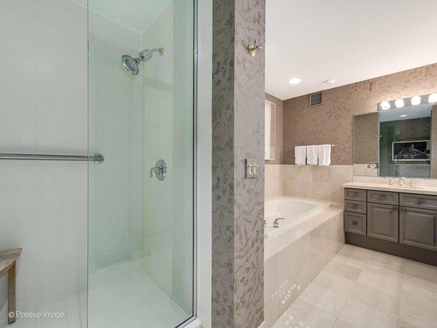 55 West Delaware Place, Unit 1101 Chicago, IL 60610 - Photo 35 of 41 a bathroom with a bathtub a sink a window and a shower