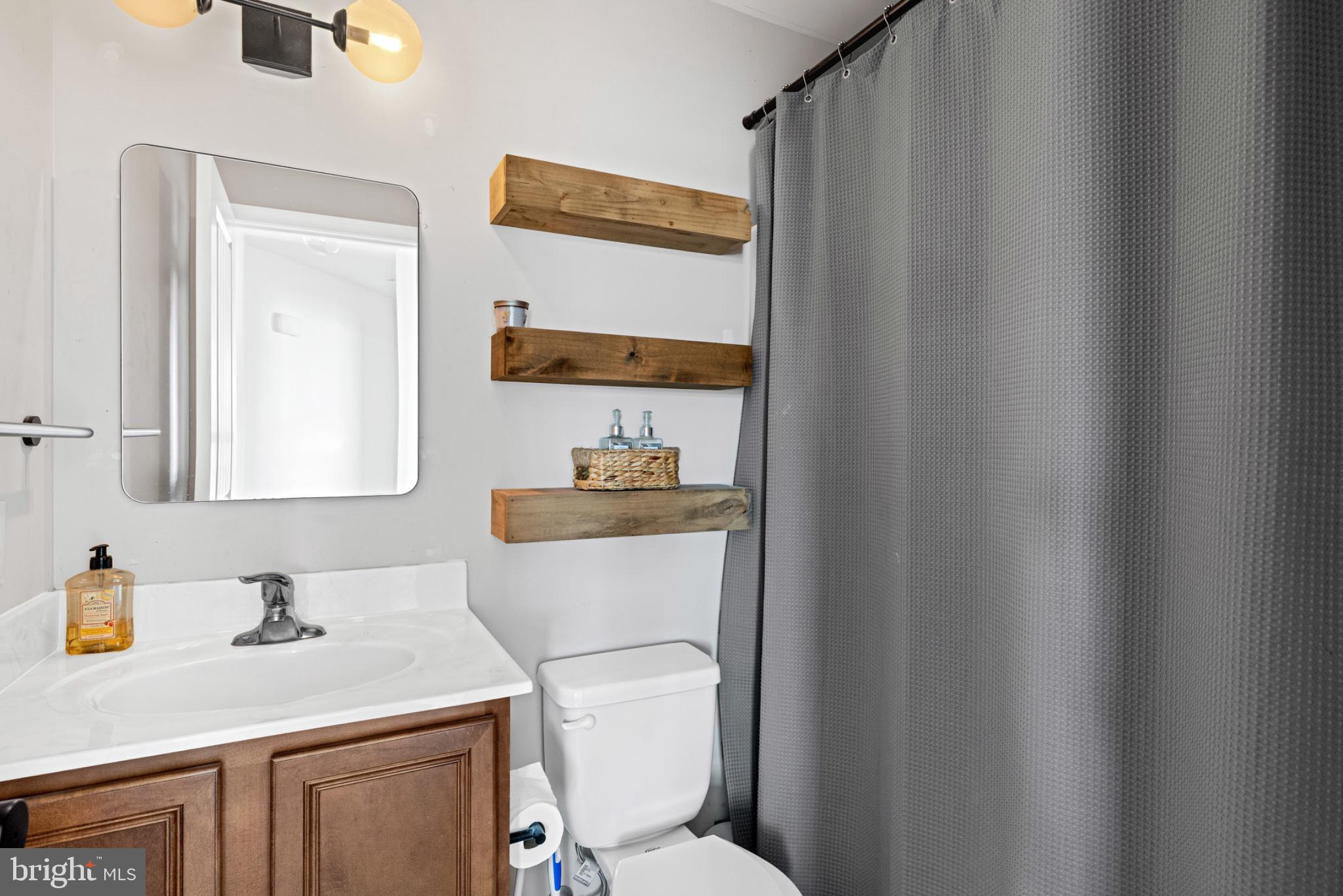 1523 Bowie Road Colonial Beach, VA 22443 - Photo 16 of 34 a bathroom with a sink a toilet and a mirror