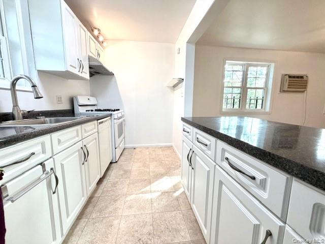 65-26B 223rd Place, Unit 2 Queens, NY 11364 - Photo 10 of 30 Kitchen featuring white cabinets, white range with gas stovetop, and dark stone counters