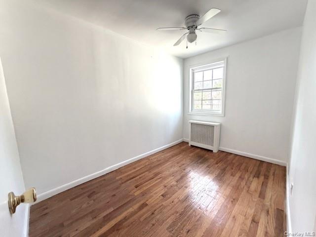 65-26B 223rd Place, Unit 2 Queens, NY 11364 - Photo 17 of 30 2nd bedroom featuring wood-type flooring, radiator heating unit, and ceiling fan